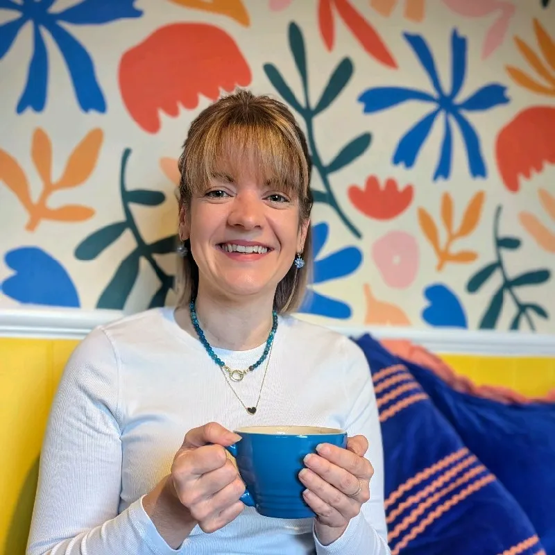 Lauren Plüss smiling with a cup of coffee